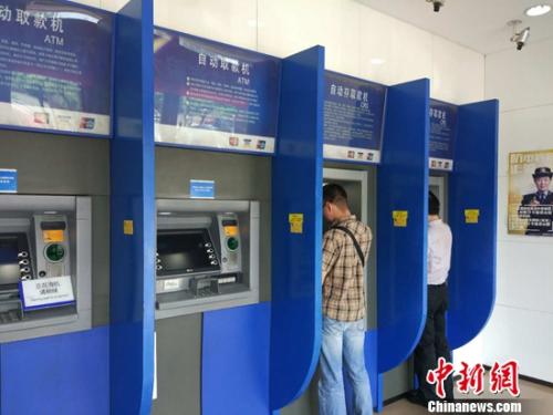 民眾在自動取款機上取款。<a target='_blank'  _fcksavedurl='http://www.chinanews.com/' ></table><p align=